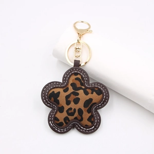 Close-up of leopard print flower keychain with gold metal clasp and white stitching details
