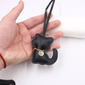 Black pebbled leather cat bag charm with gold chain necklace and sparkling crystal pendant