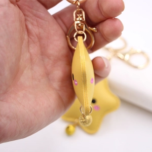 Cute yellow star-shaped faux leather keychain with smiley face and golden bell charm
