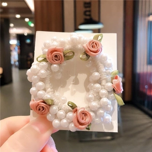Élastique à perles blanches avec roses en tissu rose et feuilles en ruban vert