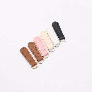 Macro detail of multi-colored PU leather DIY zipper pulls with metal D-rings on white background