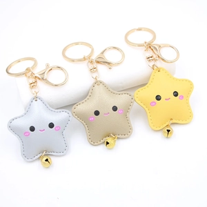 Three colorful leather star keychains in gold, silver, and yellow with bells