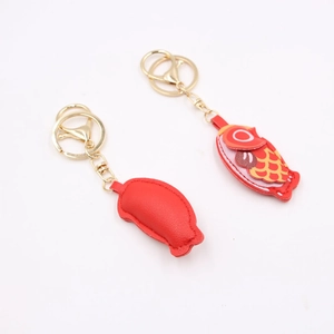 Detail of red carp leather keychains with fine stitching and golden metal lobster clasps