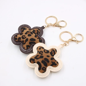 Detailed close-up of leopard print flower keychains with gold metal lobster clasp