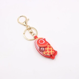 Detail of red fish leather keychain featuring golden lobster clasp and vibrant patterns