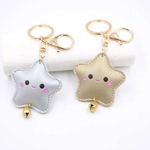 Close-up of cute star leather keychains with smiley faces and small golden bells