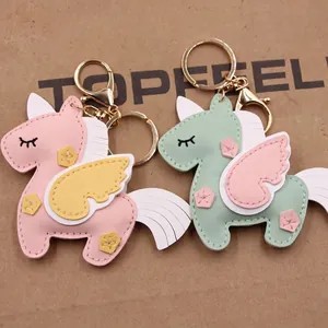 Handmade leather unicorn keychain pendants in pink and mint green with golden hardware