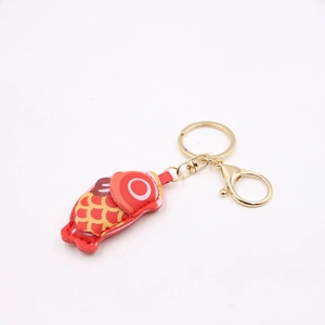 Macro view of handmade red leather carp pendant with golden metal keyring and lobster clasp
