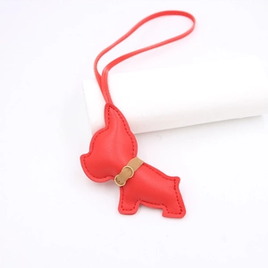Detail of red leather French bulldog bag charm with stitched strap and gold buckle