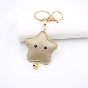 Detail of cute golden leather star keychain with smiley face and small metal bell
