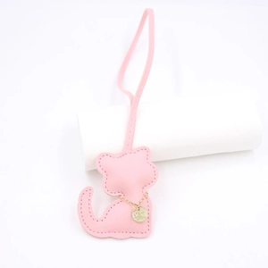 Detail of pink PU leather cat bag charm with decorative gold chain and stitching