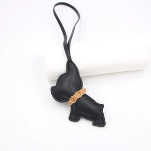 Detailed close-up of a black leather French Bulldog charm with lychee texture and collar