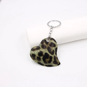 Leopard print heart-shaped leather keychain with silver metal ring on white background