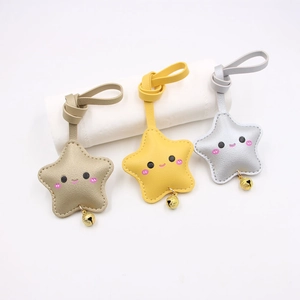 Set of three cute star-shaped leather keychains in gold, yellow, and silver with smiling faces