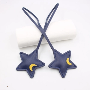 Detail of blue leather star and moon pendant with decorative stitching and 3D filling