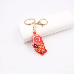 Macro detail of red carp leather charm with golden keychain and lobster clasp
