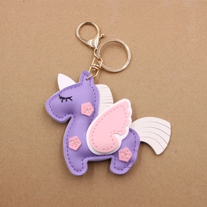 Detail of handmade purple leather unicorn keychain with gold clasp and pink wings