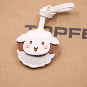 Vue détaillée du charm de sac mouton montrant la texture du cuir blanc et le cœur découpé
