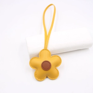 Handcrafted yellow leather flower bag charm with fine stitching and long lanyard