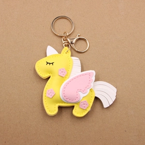 Detail of yellow unicorn leather keychain with pink wings and golden lobster clasp
