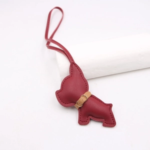 Detail of red pebbled leather French Bulldog bag charm with neat stitching and brown collar