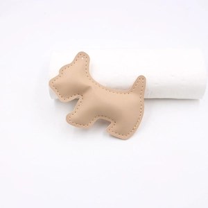 Detail of beige leather Schnauzer dog charm with white stitching and hanging hole