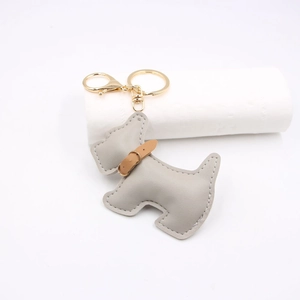 Detail of grey leather Schnauzer keychain with fine stitching and golden metal clasp