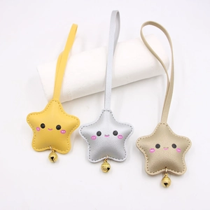Detailed view of three cute star leather keychains in yellow, silver, and champagne gold
