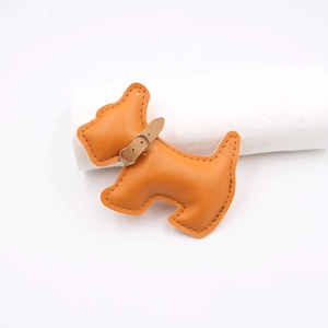 Close-up of orange leather Scottie dog charm with detailed stitching and collar