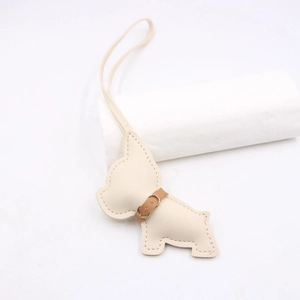 Close-up of cream leather French Bulldog charm with brown collar and precise stitching
