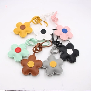 Detail of seven colorful leather flower charms with decorative stitching and long straps
