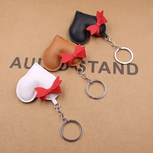 Handmade leather heart keychains with red bows in black, white and brown colors