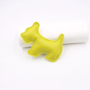 Detailed close-up of a neon yellow leather puppy charm with precise perimeter stitching