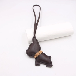 Detail of dark brown leather French Bulldog charm with gold metal clasp and long lanyard
