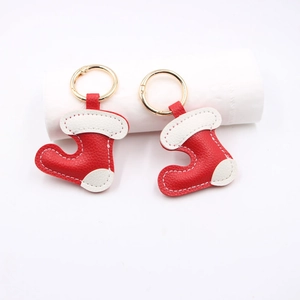 Litchi textured PU leather Christmas boot keychain with gold metal ring on white background