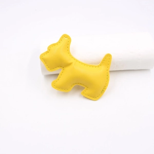 Detail view of yellow leather Scottish Terrier charm with matching edge stitching
