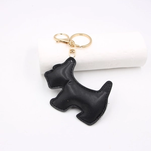 Detailed view of a black leather Scottie dog keychain with gold metal hardware and stitching