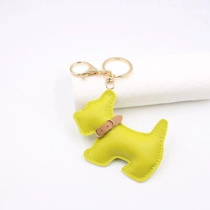Detail of yellow leather dog keychain featuring golden hardware and brown collar