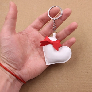 Handmade white leather heart keychain with a red bow and silver metal ring accessory