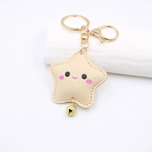 Macro view of beige PU leather star keychain with fine stitching and golden bell detail
