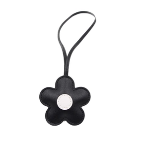 Minimalist leather flower bag charm with black floral petals and white center detail