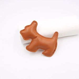 Brown leather dog-shaped bag charm with fine stitching shown on a white background