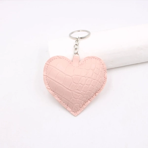 Dettaglio del portachiavi rosa a forma di cuore con trama coccodrillo e anello argento