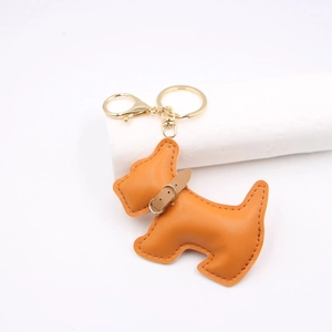 Detail of orange faux leather dog keychain with gold hardware and hand-stitched edges