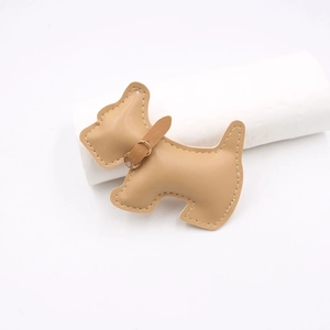 Detail view of handmade faux leather terrier charm with fine stitching and gold hardware