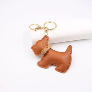 Brown leather schnauzer dog keychain with gold metal clasp on a white background