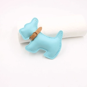 Close-up of sky blue leather Scottie dog charm with lychee grain and gold metal buckle