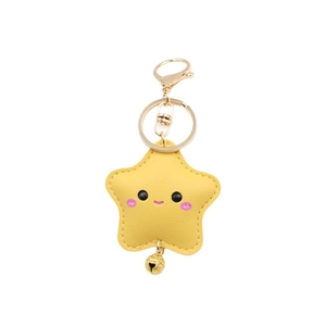 Cute yellow leather star keychain with smiley face and golden bell on white background