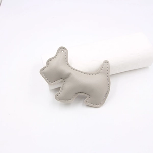 Detail of grey Schnauzer dog leather charm with neat edge stitching and punch hole