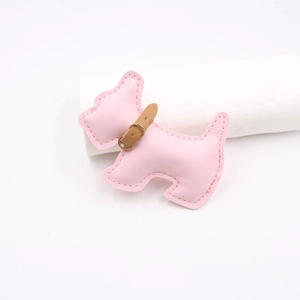 Detail of pink faux leather schnauzer bag charm with stitching and gold buckle